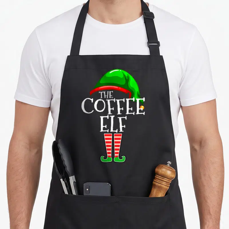 Coffee personalized family aprons - The Coffee Elf text forming a body with green hat and red striped legs — shown on a black cotton canvas apron against a white background