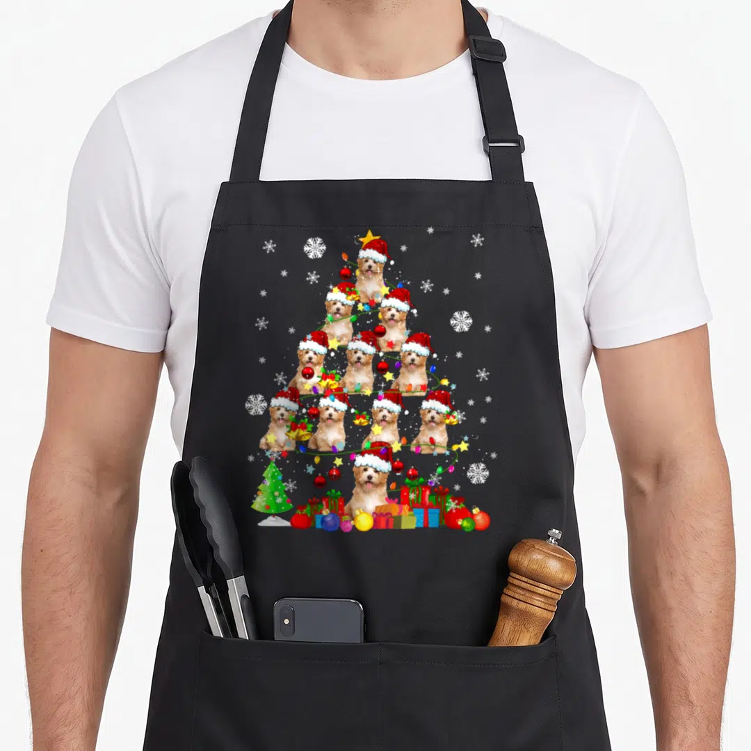 Santa cavapoo christmas tree apron - Triangle of tan dogs in red Santa hats with Christmas lights, ornaments — shown on a black cotton canvas apron against a white background