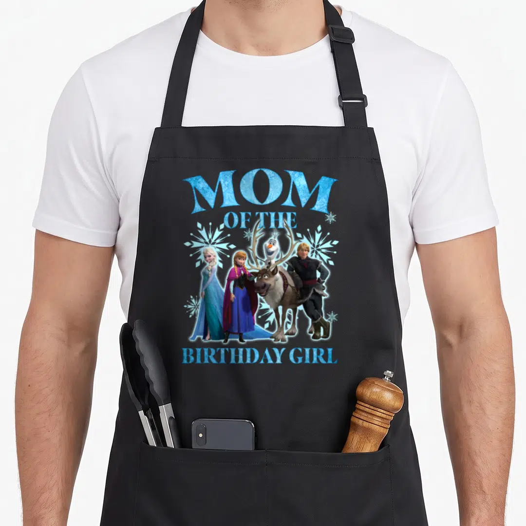 Frozen birthday apron - Mom of the Birthday Girl text with Frozen characters and blue snowflakes — shown on a black cotton canvas apron against a white background