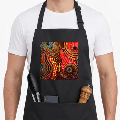 Painting australian apron - Abstract dot painting with red yellow white and black concentric circles on black background — shown on a black cotton canvas apron against a white background