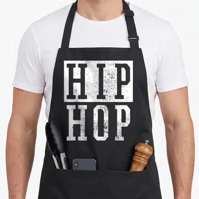 Ninety hip aprons - Stacked white distressed HIP HOP text design on grey background — shown on a black cotton canvas apron against a white background