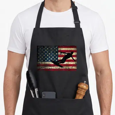Flag wakeboarding apron - Black wakeboarder silhouette over distressed USA flag in red white blue and black — shown on a black cotton canvas apron against a white background
