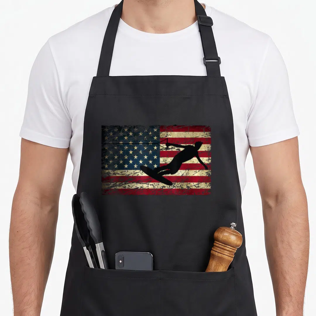 Flag wakeboarding apron - Black wakeboarder silhouette over distressed USA flag in red white blue and black — shown on a black cotton canvas apron against a white background