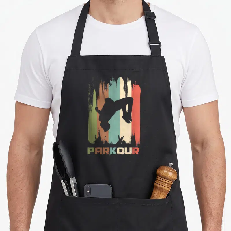 Freerunner parkour apron - Grey athlete silhouette over five distressed stripes in green orange blue cream and red — shown on a black cotton canvas apron against a white background