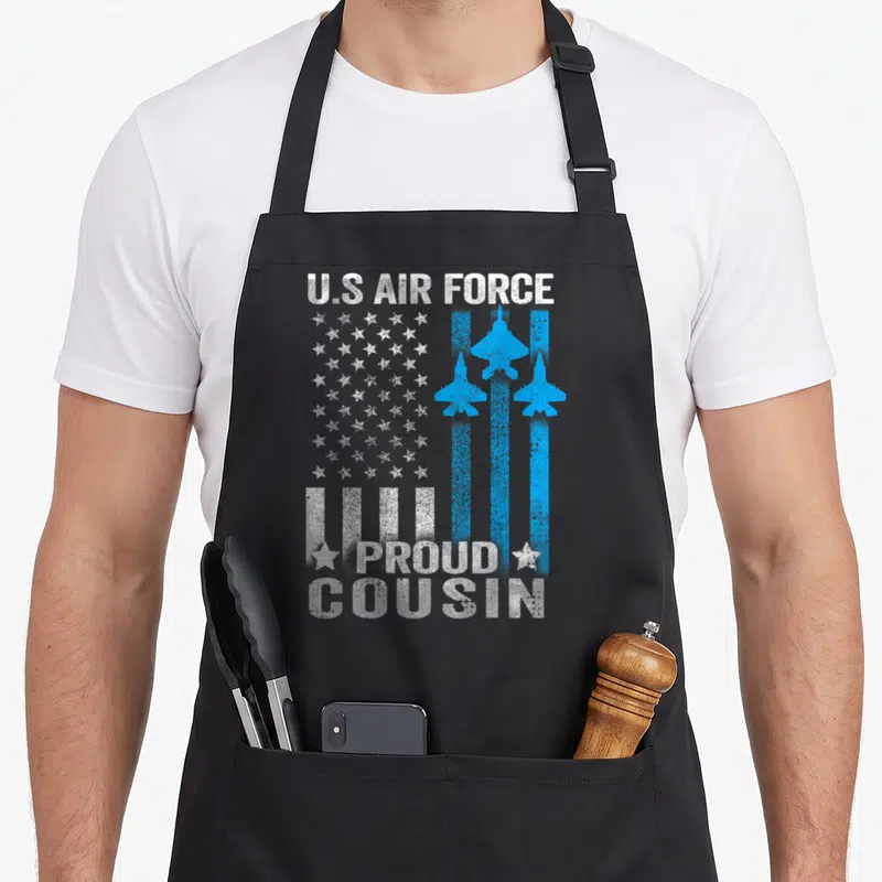 Cousin us aprons - Distressed US Air Force text with blue jet planes and stars forming a flag pattern above proud — shown on a black cotton canvas apron against a white background