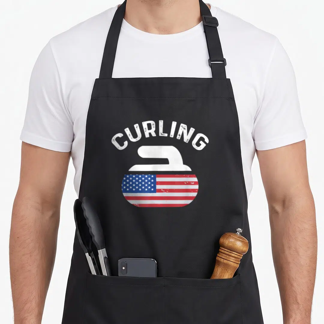 Curling american flag apron - Arched CURLING text above a stone graphic with red white blue flag pattern — shown on a black cotton canvas apron against a white background