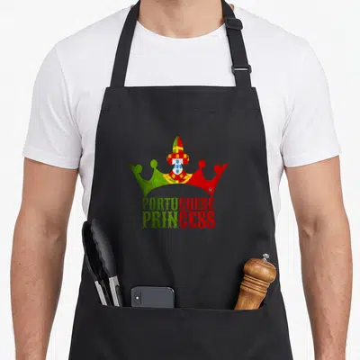 Princess portuguese apron - Crown filled with Portuguese flag colors above split green and red text reading PORTUGUESE — shown on a black cotton canvas apron against a white background