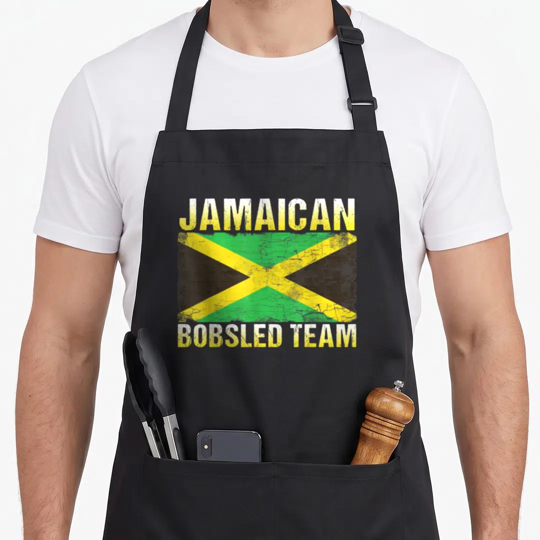 Jamaican jamaica bobsled apron - Distressed Jamaican flag centered between JAMAICAN and BOBSLED TEAM text in yellow — shown on a black cotton canvas apron against a white background