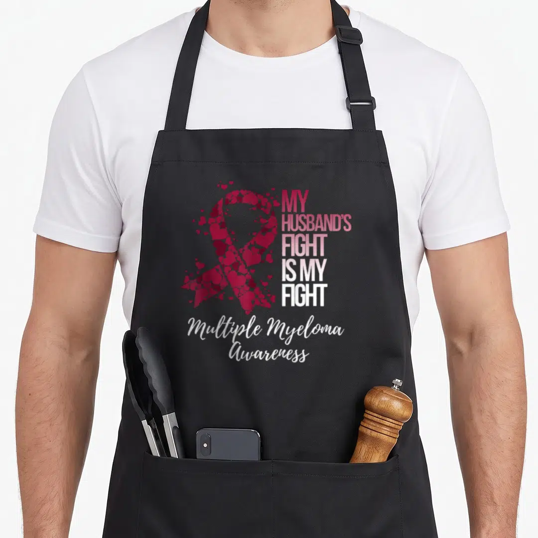 Fight husband apron - Heart ribbon and text My Husband's Fight Is My Fight Multiple Myeloma Awareness — shown on a black cotton canvas apron against a white background