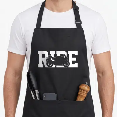 Racer motorcycle aprons - White RIDE text with motorcycle silhouette cutout inside letters — shown on a black cotton canvas apron against a white background