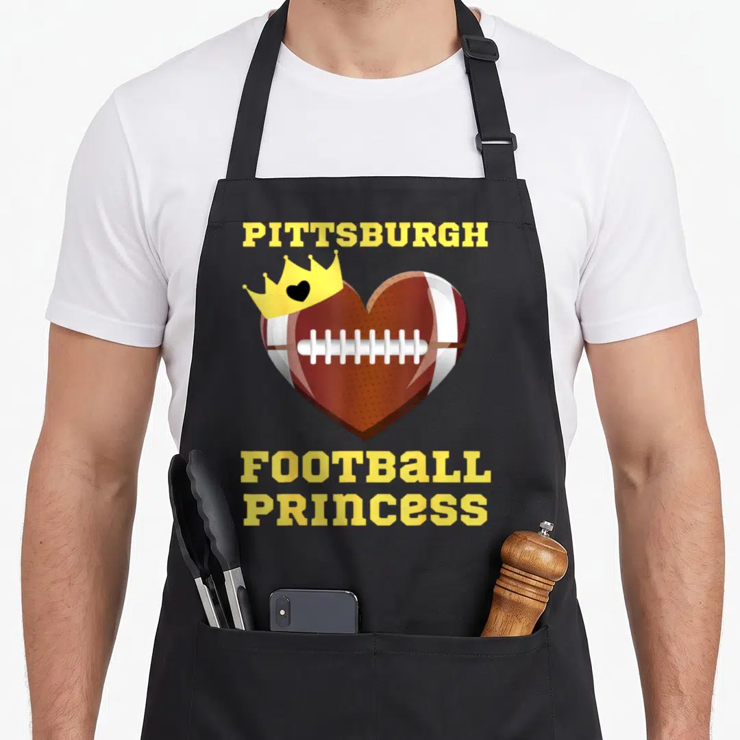 Pittsburgh princess apron - Heart shaped football with yellow crown and Pittsburgh Football Princess text — shown on a black cotton canvas apron against a white background