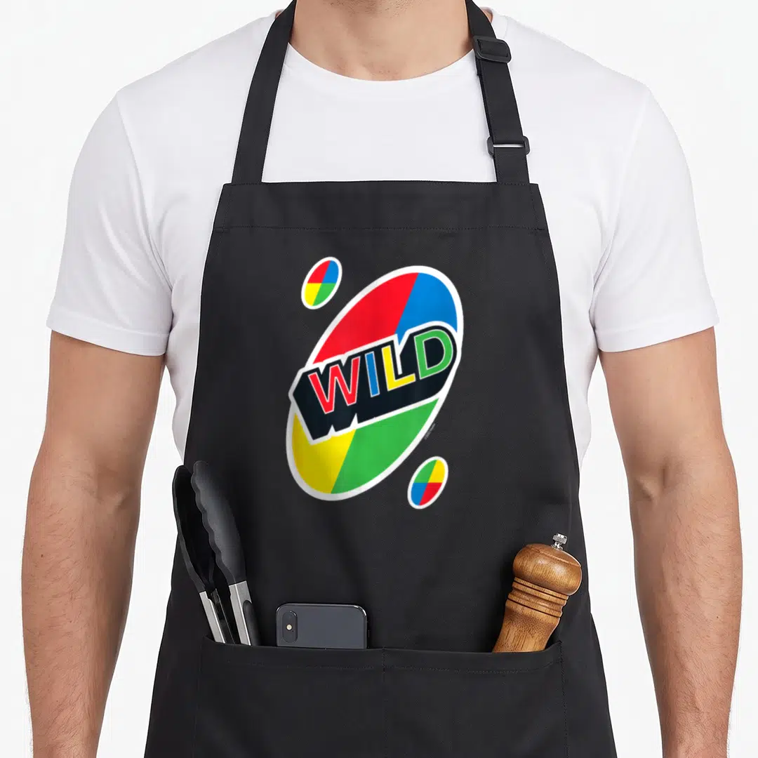 Wild card uno apron - WILD text inside large multi-colored oval with two smaller ovals in red blue yellow green white — shown on a black cotton canvas apron against a white background
