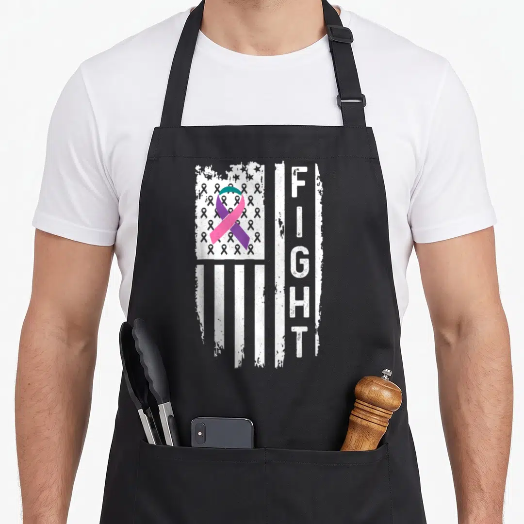Thyroid american flag apron - Distressed white flag with teal purple pink ribbon and vertical FIGHT text — shown on a black cotton canvas apron against a white background