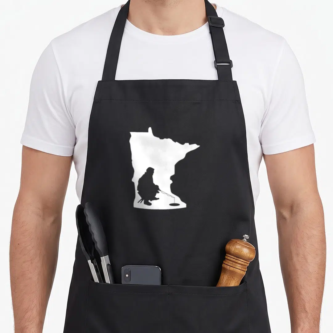 Ice minnesota apron - White Minnesota state silhouette containing a seated person holding a fishing rod over a hole — shown on a black cotton canvas apron against a white background