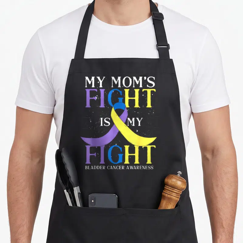 Bladder ribbon apron - Purple yellow blue awareness ribbon overlapping MY MOM'S FIGHT IS MY FIGHT text with black — shown on a black cotton canvas apron against a white background