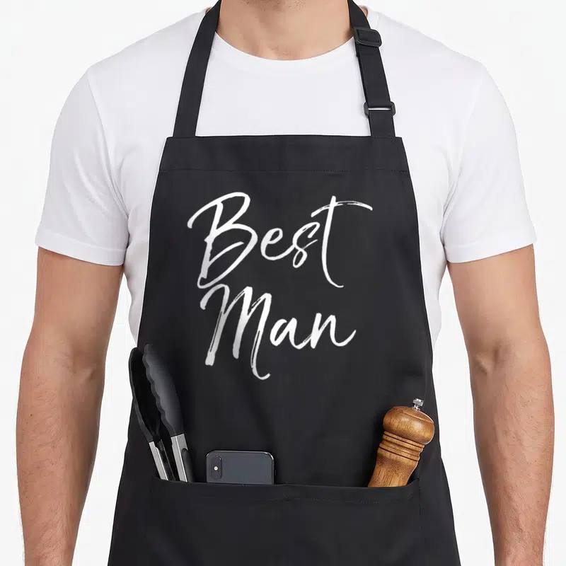 Groomsmen bridal apron - White stacked script text reading Best Man on grey background — shown on a black cotton canvas apron against a white background