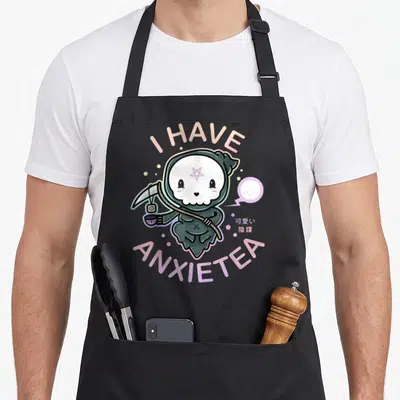 Pastel tea apron - Cartoon grim reaper holding tea cup with I HAVE ANXIETEA text in pastel colors — shown on a black cotton canvas apron against a white background