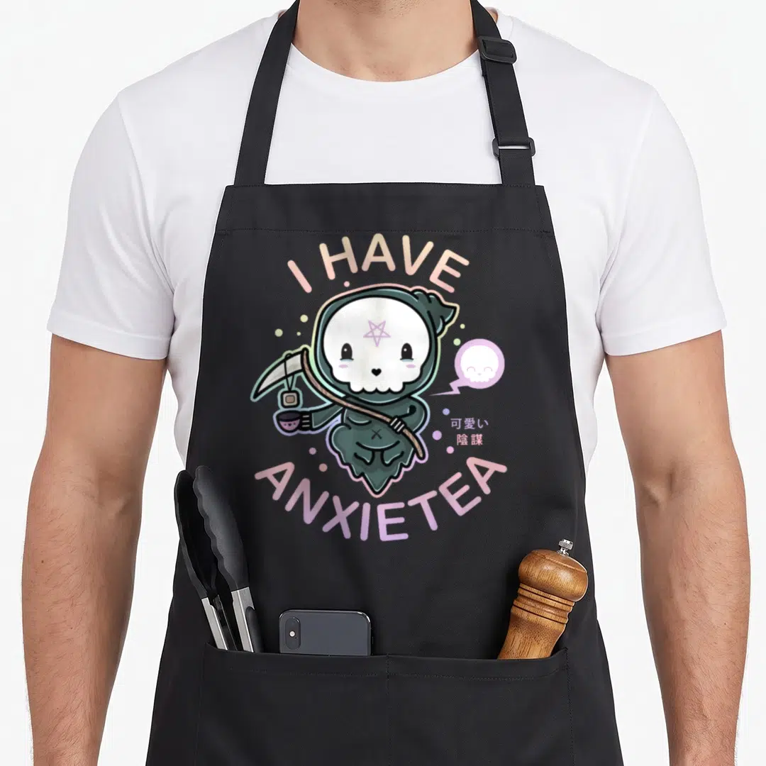 Pastel tea apron - Cartoon grim reaper holding tea cup with I HAVE ANXIETEA text in pastel colors — shown on a black cotton canvas apron against a white background