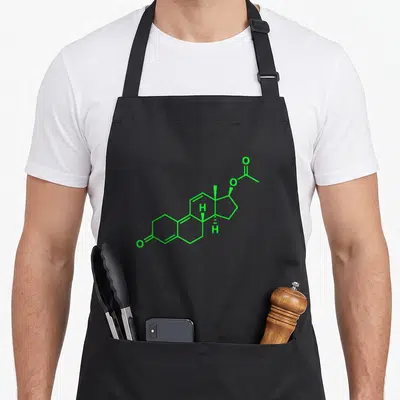 Trenbolone bodybuilding apron - Green chemical skeletal formula line art diagram centered on grey background — shown on a black cotton canvas apron against a white background