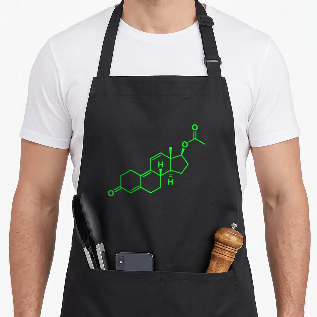 Trenbolone bodybuilding apron - Green chemical skeletal formula line art diagram centered on grey background — shown on a black cotton canvas apron against a white background