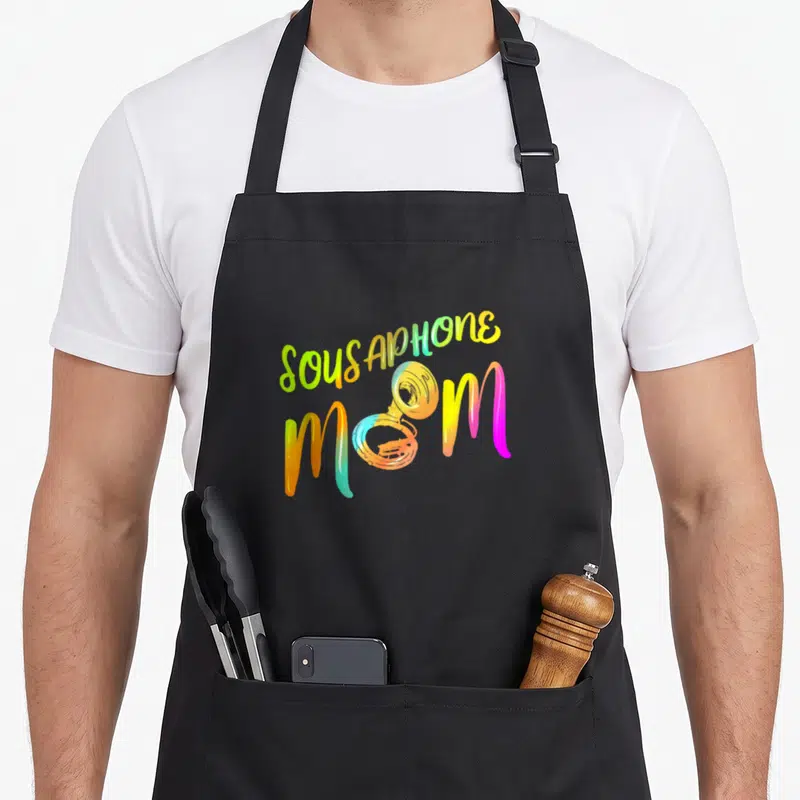 Member tuba apron - Colorful SOUSAPHONE MOM text with brass instrument replacing the O in Mom — shown on a black cotton canvas apron against a white background