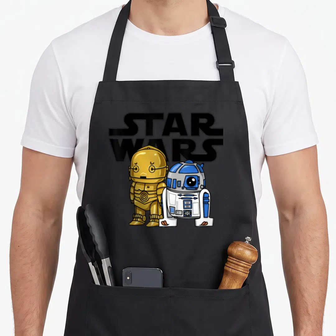 3po cartoon apron - Two small droids stand before STAR WARS text in cartoon style with black gold blue white colors — shown on a black cotton canvas apron against a white background