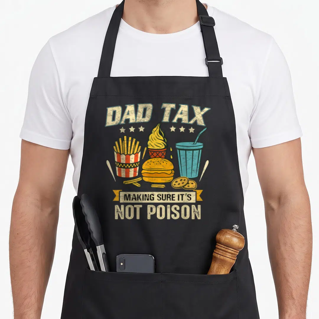 Tax sure making an apron - DAD TAX MAKING SURE IT'S NOT POISON fast food cartoon print on black bib — shown on a black cotton canvas apron against a white background