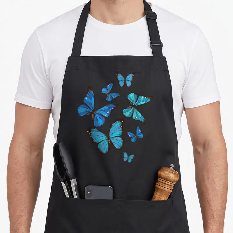 Morpho butterfly apron - Six blue butterflies with brown outlines scattered in various sizes and orientations — shown on a black cotton canvas apron against a white background