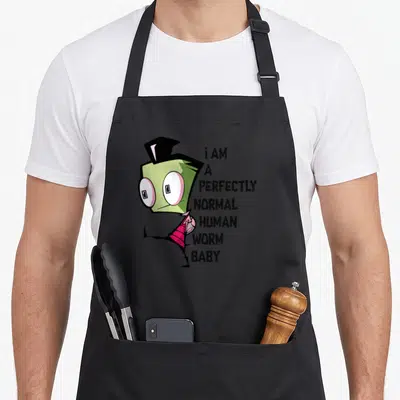 Invader worm apron - Green cartoon character next to stacked text reading i AM A PERFECTLY NORMAL HUMAN WORM BABY — shown on a black cotton canvas apron against a white background