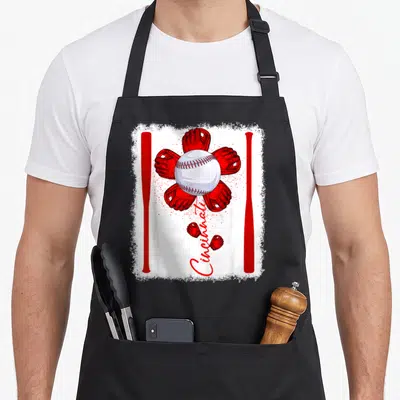 Flower cincinnati baseball apron - White baseball surrounded by four red gloves and two bats with red Cincinnati script — shown on a black cotton canvas apron against a white background