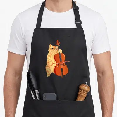 Kitten cello apron - Cartoon orange tabby cat standing and playing a cello with a bow — shown on a black cotton canvas apron against a white background