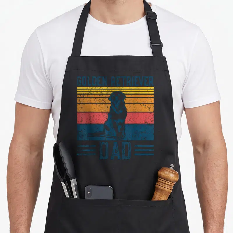 Funny dog golden retriever apron - Retro grey sitting dog over blue yellow orange red grey stripes with Golden — shown on a black cotton canvas apron against a white background