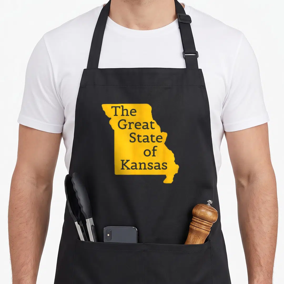 State kansas girl apron - Yellow Missouri map silhouette with grey text reading The Great State of Kansas — shown on a black cotton canvas apron against a white background