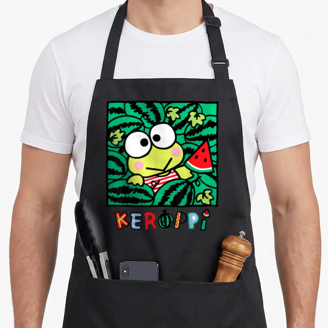 Keroppi watermelon apron - Cartoon frog holding red watermelon slice inside green patterned square with KEROPPI text — shown on a black cotton canvas apron against a white background