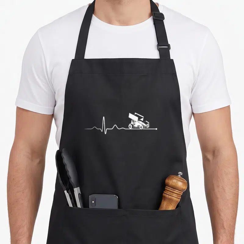 Sprint racing apron - White line-art off-road vehicle on a horizontal heartbeat pulse line — shown on a black cotton canvas apron against a white background
