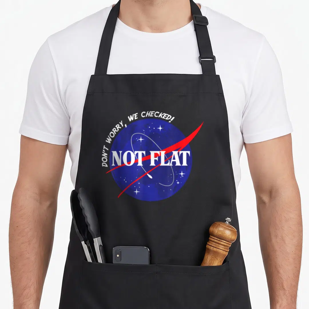 Worry flat apron - Blue globe with white stars and red swoosh reading NOT FLAT — shown on a black cotton canvas apron against a white background