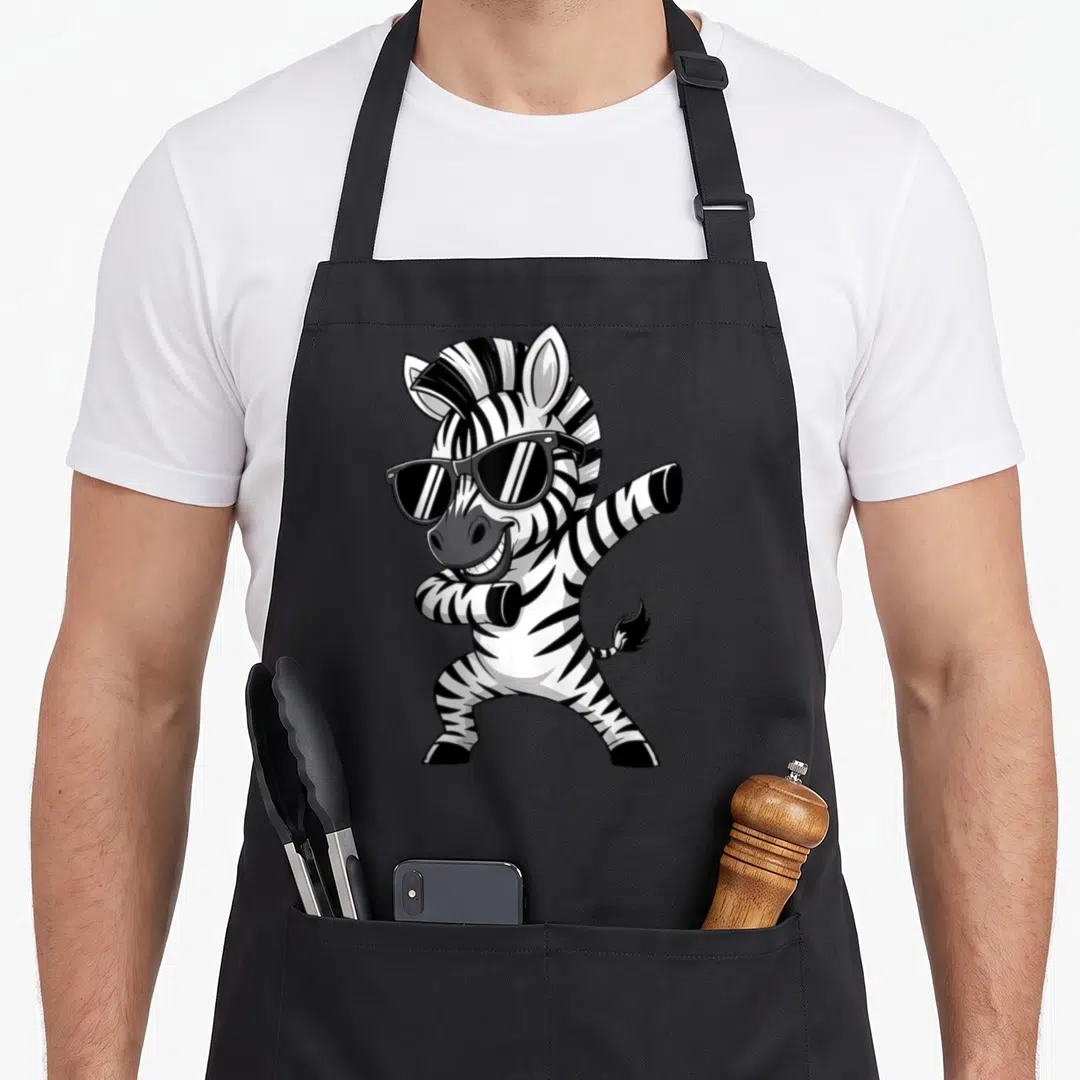 Clothe animal print apron - Cartoon zebra wearing sunglasses and striking a dynamic pose in black and white stripes — shown on a black cotton canvas apron against a white background