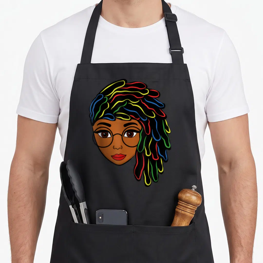 Dreadlock hair apron - Cartoon woman face with glasses and colorful dreadlocks in red yellow green blue — shown on a black cotton canvas apron against a white background