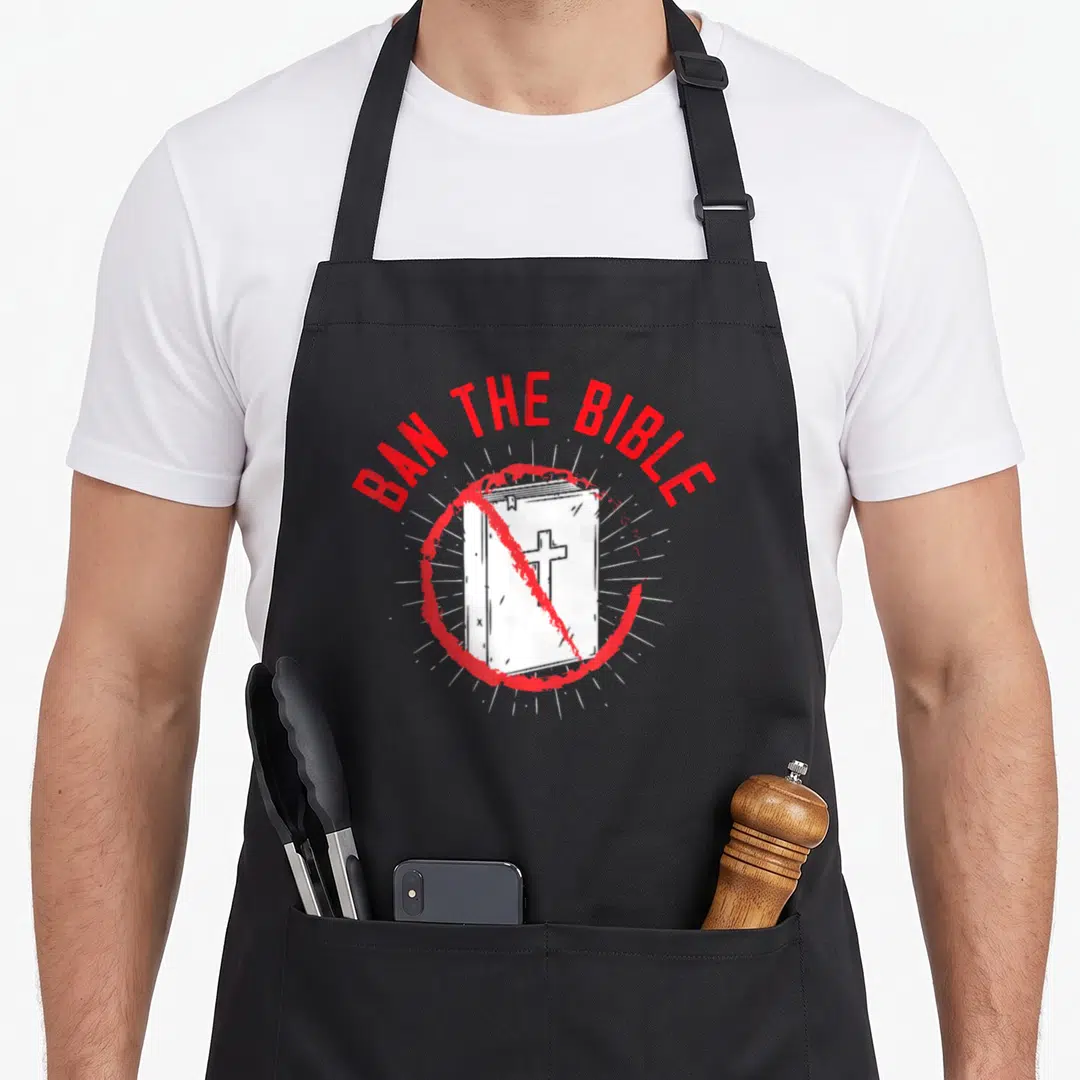 Ban agnostic apron - Red prohibition circle over a distressed bible with white rays and arched text — shown on a black cotton canvas apron against a white background
