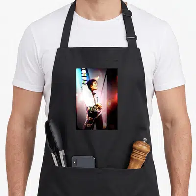 Jackson michaels apron for men - Photo of Michael Jackson on stage with one arm raised wearing a white jacket — shown on a black cotton canvas apron against a white background