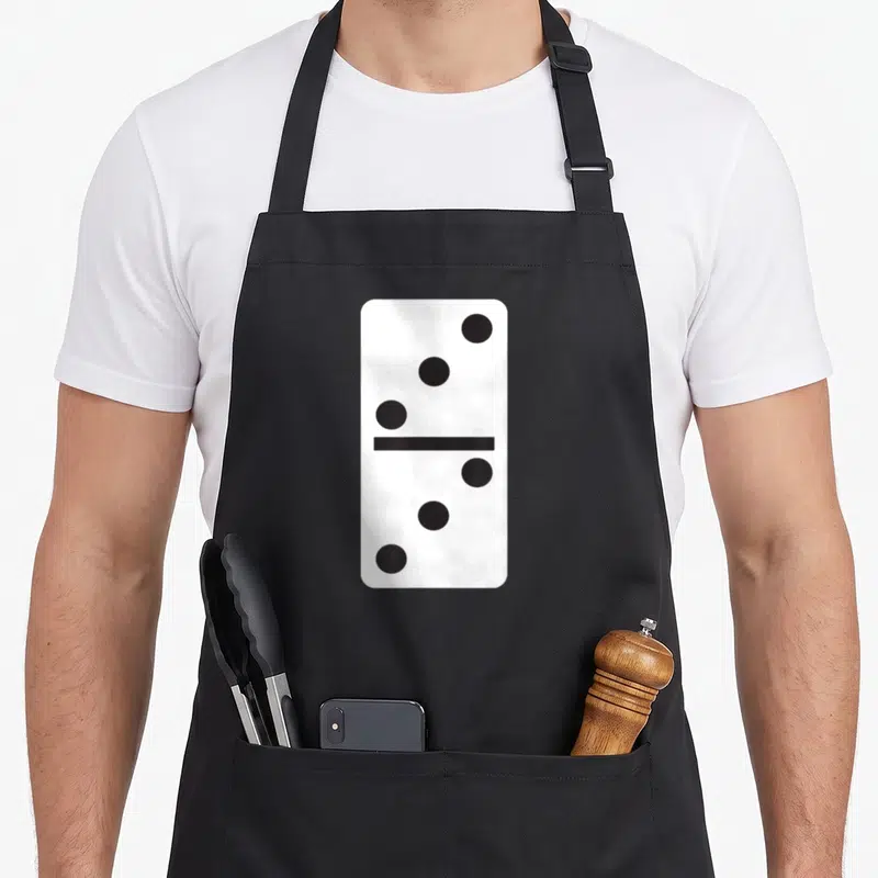 Dominoe halloween apron - Vertical white domino tile with three black dots on top and three on bottom — shown on a black cotton canvas apron against a white background