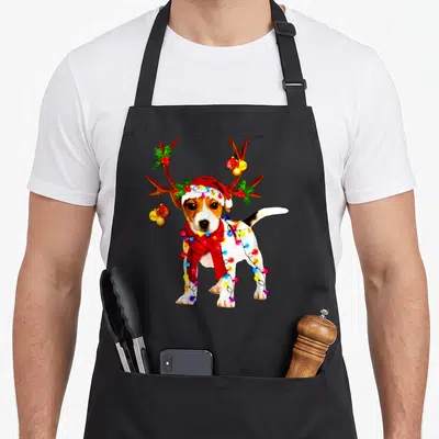 Santa reindeer apron - Realistic jack russell wearing santa hat, red scarf, antlers with holly and multicolored lights — shown on a black cotton canvas apron against a white background