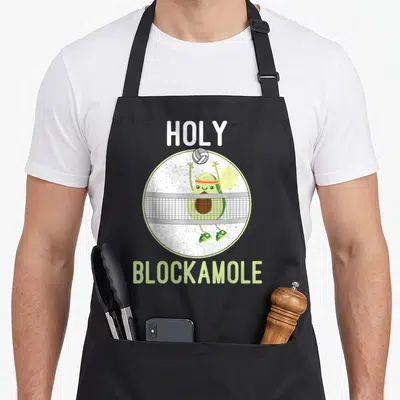 Holy avocado apron - Cartoon avocado jumping over net with holy blockamole text in green and white — shown on a black cotton canvas apron against a white background