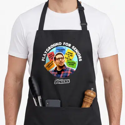 Impractical grade turkeys apron - Man in glasses surrounded by colorful notes reading COMPLAINING BOOTH and BEEF — shown on a black cotton canvas apron against a white background