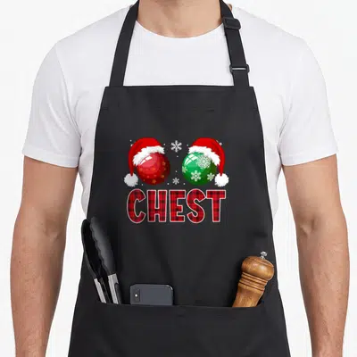 Nut chestnut couples christmas aprons - Two Santa-hatted Christmas ornaments with snowflakes and CHEST text in red plaid — shown on a black cotton canvas apron against a white background