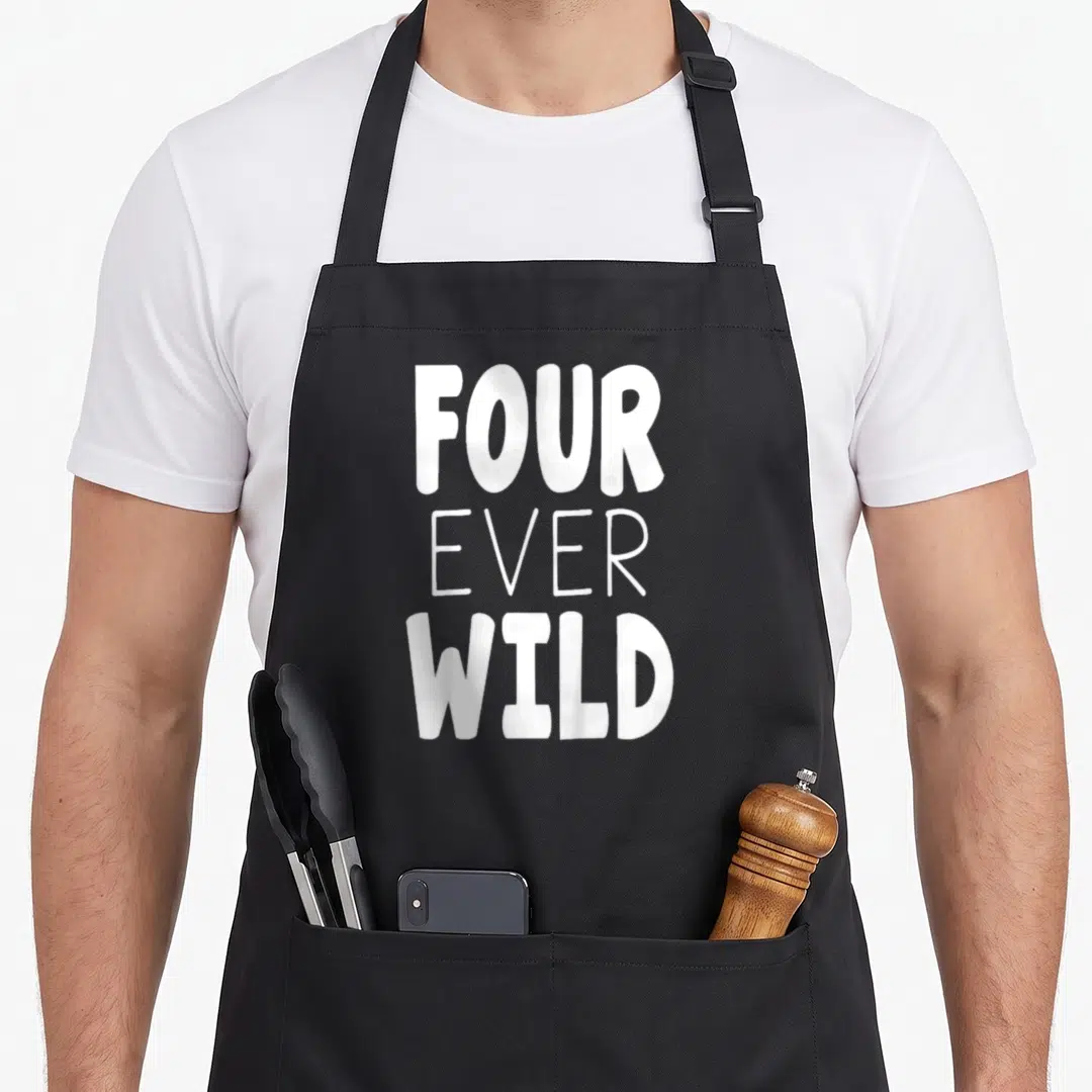 Four birthday apron - White stacked text reading FOUR EVER WILD in three lines — shown on a black cotton canvas apron against a white background