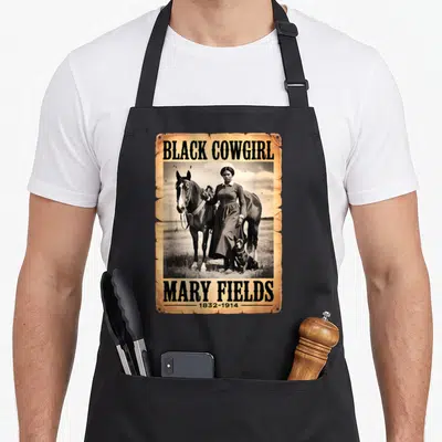 Mary western aprons - Tan distressed frame with Black Cowgirl text and photo of Mary Fields with horse and dog — shown on a black cotton canvas apron against a white background