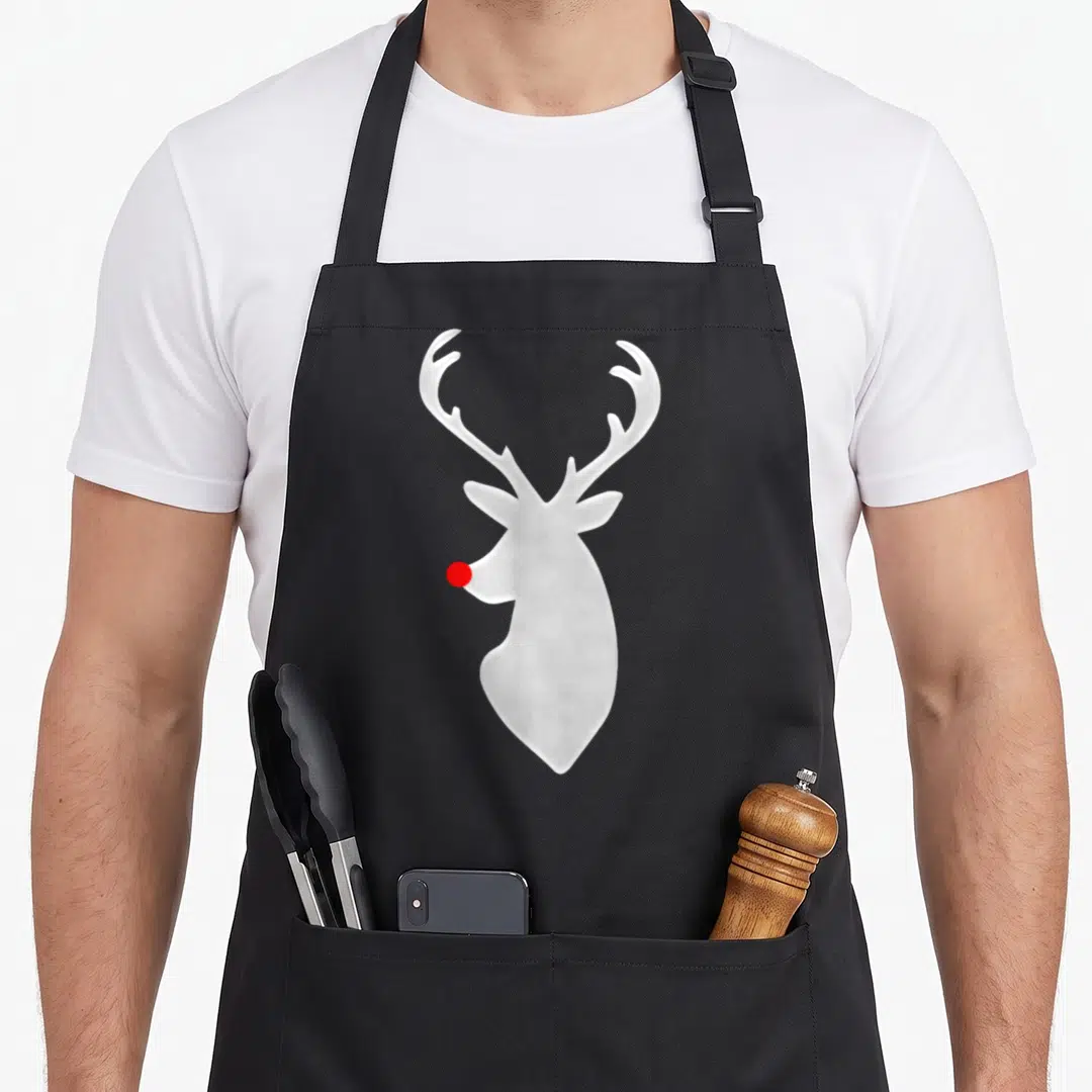 Hip christmas apron - White reindeer head silhouette with single red nose in minimalist style — shown on a black cotton canvas apron against a white background