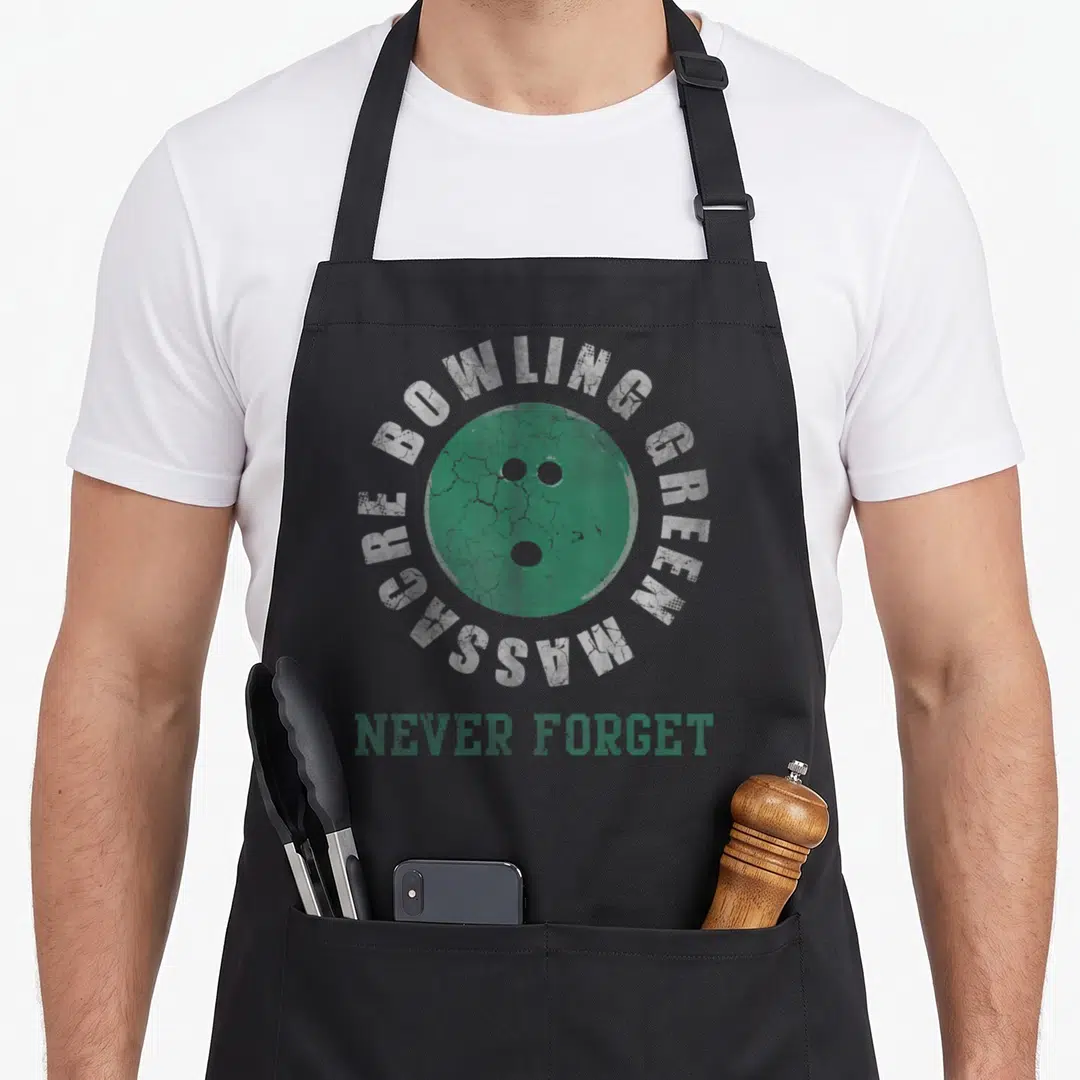 Massacre bowling green apron - Distressed green bowling ball with arched white text and bottom slogan — shown on a black cotton canvas apron against a white background